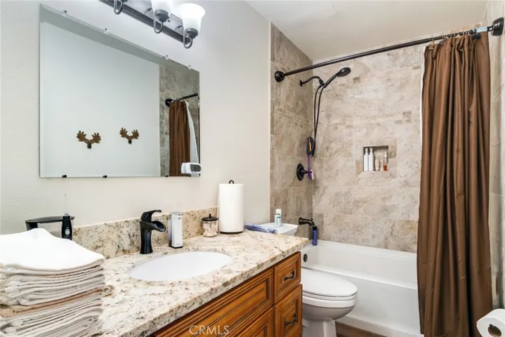 Hall Bathroom with Tiled Tub/Shower and Stone Counter Top