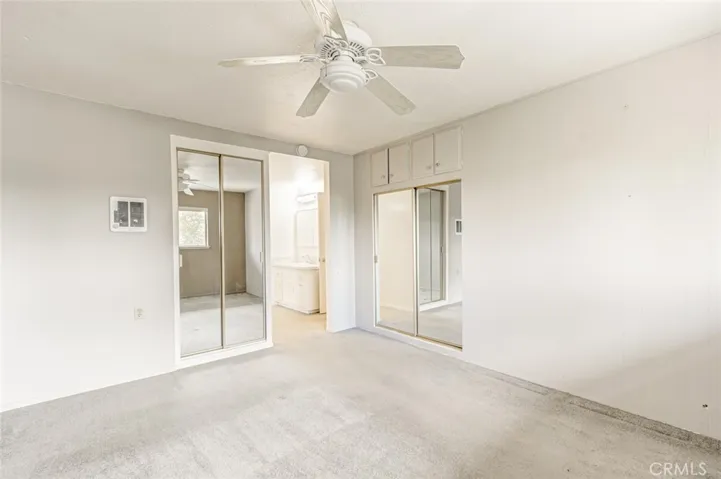 Master bedroom with 2 mirrored closets and entrance to master bathroom