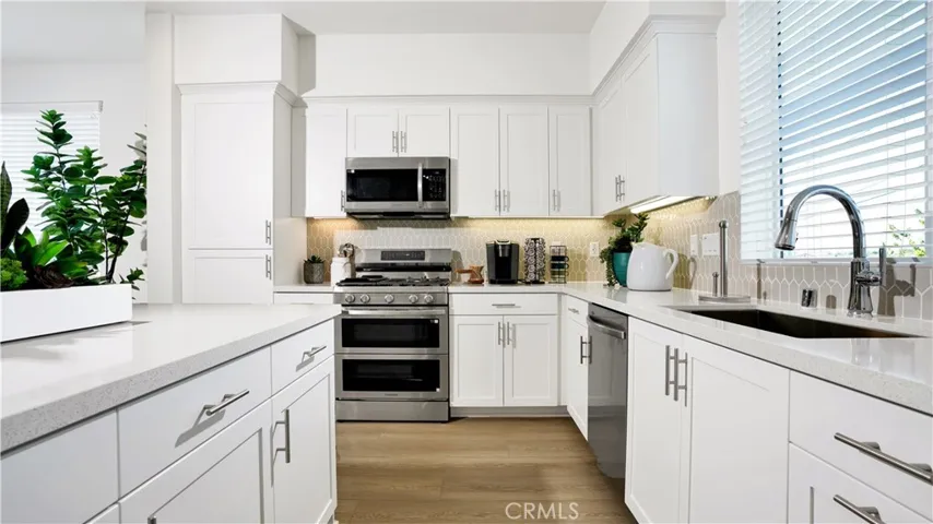 enjoy quartz counters with a full height tile splash at the kitchen