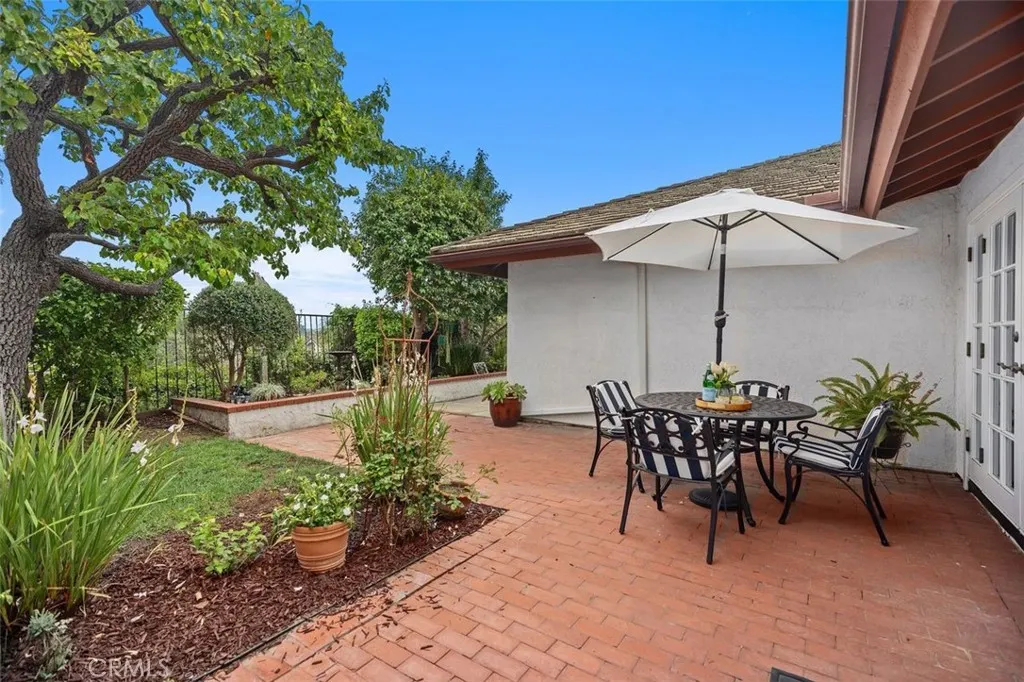 The rear patio area is located outside of the living room with plenty of mature landscaping to enjoy.