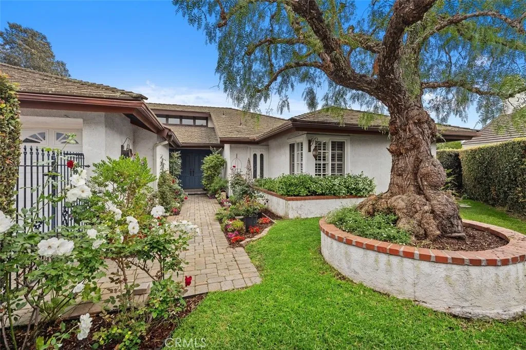 Enter your welcoming private gated courtyard with a lovely tree and flowers.