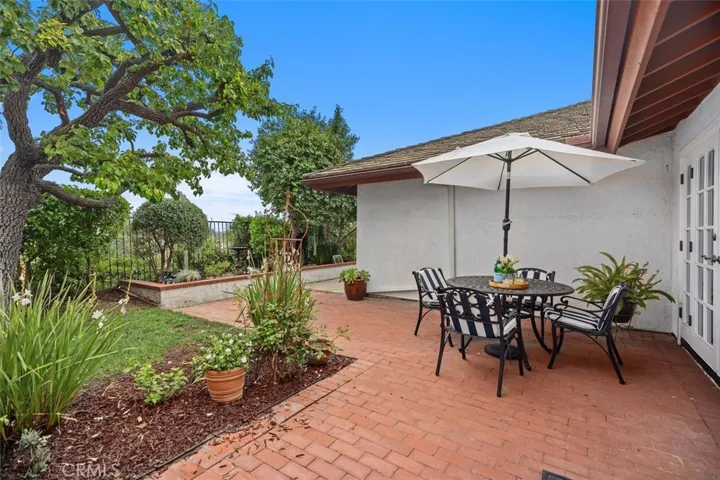 The rear patio area is located outside of the living room with plenty of mature landscaping to enjoy.