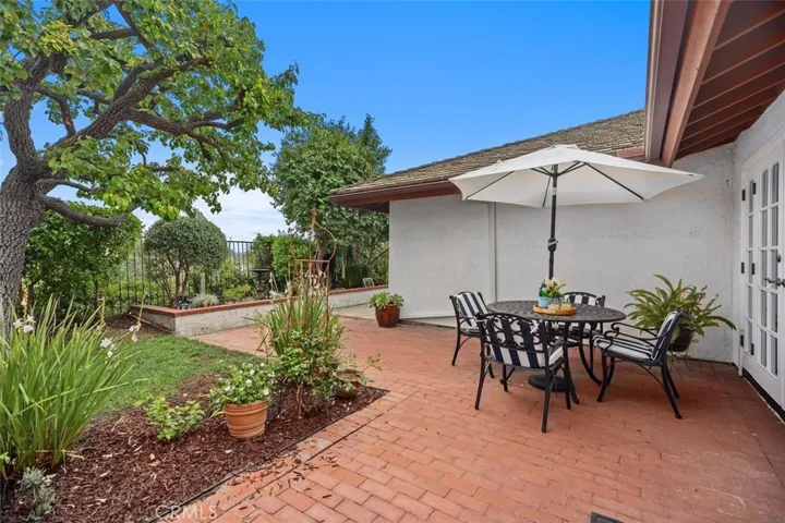 The rear patio area is located outside of the living room with plenty of mature landscaping to enjoy.