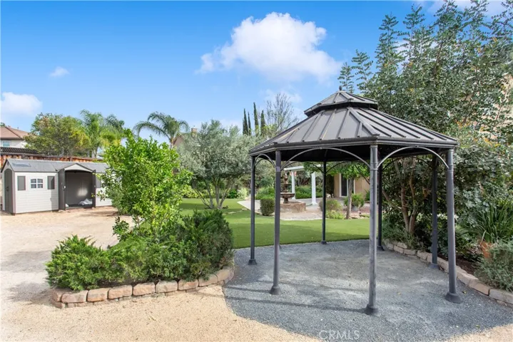 Cute gazebo for another seating area to enjoy. Extra large shed also staying with house