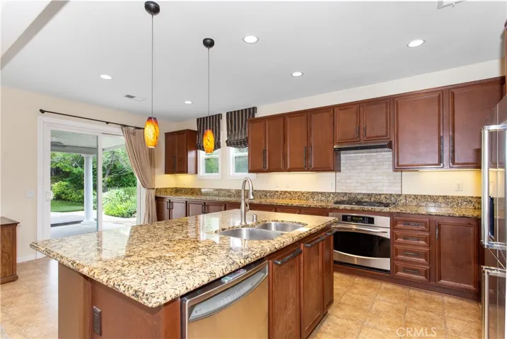 Big kitchen w/ wall-to-wall cabinetry, granite counters, stove tile backsplash + all kitchen appliances.