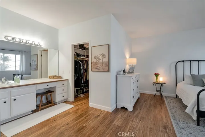 Large walk-in closet and primary bathroom with vanity seating