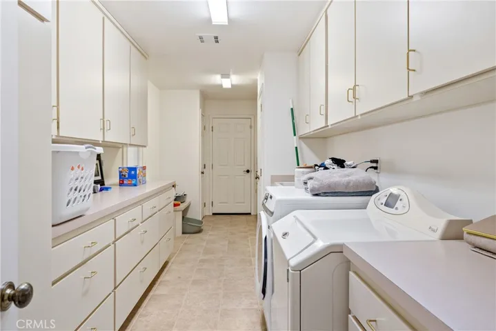 Generous laundry room featuring extensive cabinetry and storage