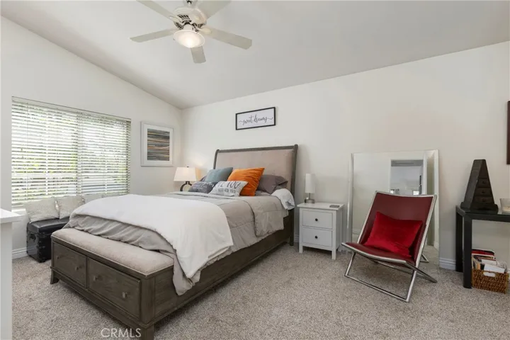 The primary bedroom suite with high ceilings and ceiling fan