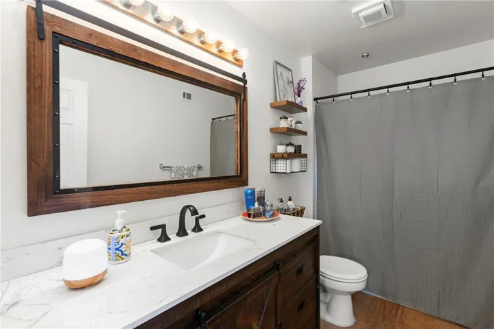 The second full bathroom with marble counters, updated faucets, fixtures, and mirror, and a tub/shower combination.