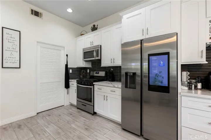 Recently remodeled kitchen with white cabinetry, quarts counters, and stainless steel appliances