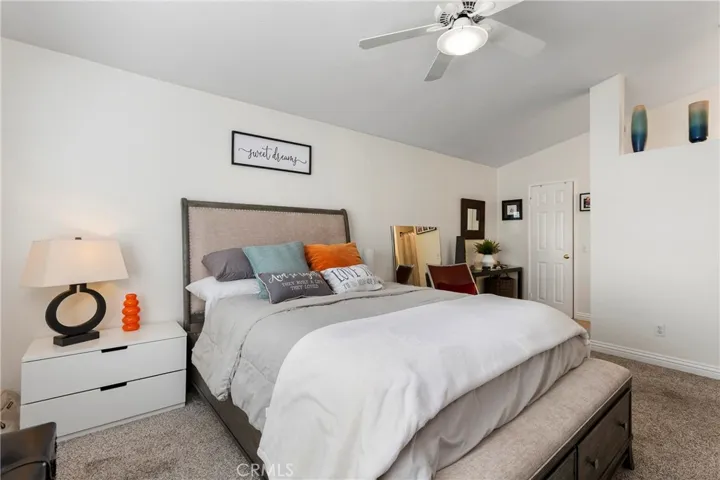 The primary bedroom suite with high ceilings and ceiling fan