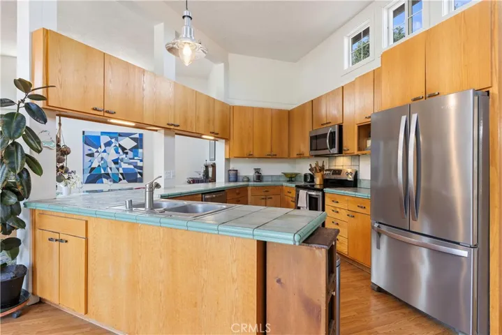 Kitchen with tile counters, high ceiling and SS All electric appliances