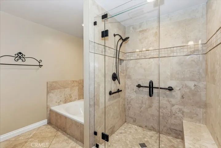 Tiled walk in shower w/bench & grab handles