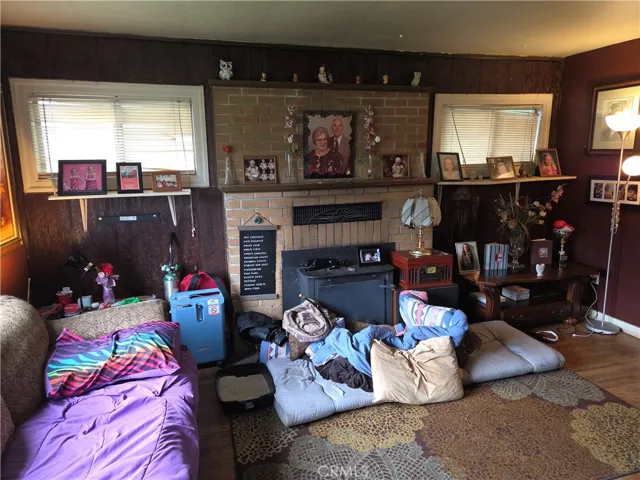 South wall of living room with fireplace and woodstove insert.