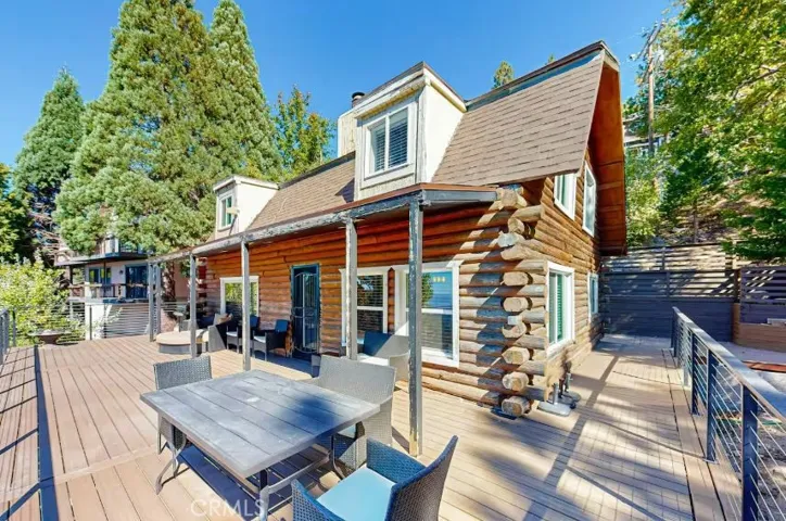 View of the backside of the log cabin showing the wrap-around deck