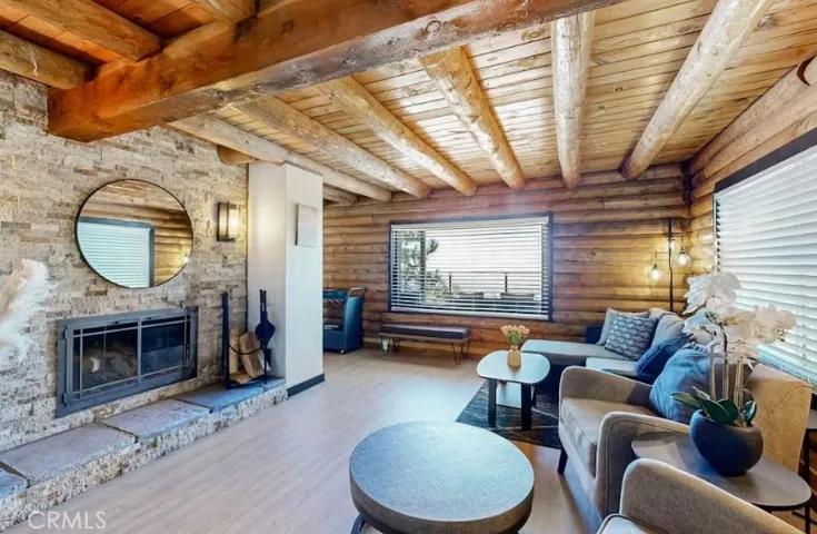 Fireplace with stackstone and large portrait window looking out to the deck