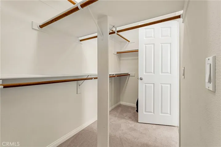 VIEW OF ONE OF THE WALK IN CLOSETS IN THE PRIMARY ENSUITE