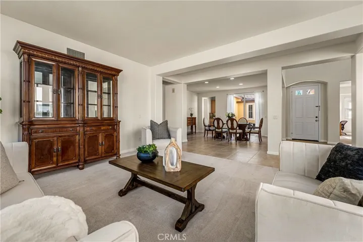 VIEW FROM SPACIOUS FORMAL LIVING ROOM INTO FORMAL DINING ROOM AND FRONT COURTYARD.