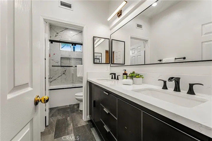 REMODELED SECONDARY BATHROOM UPSTAIRS WITH PRIVACY TUB/SHOWER ENCLOSURE AND DUAL SINKS