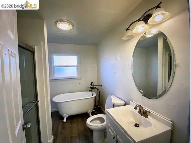 Bathroom with vanity, dark wood-type flooring, a soaking tub, and a shower stall