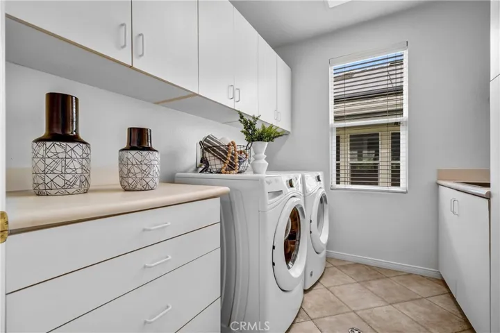 Convenient upstairs laundry room with sink and folding counter