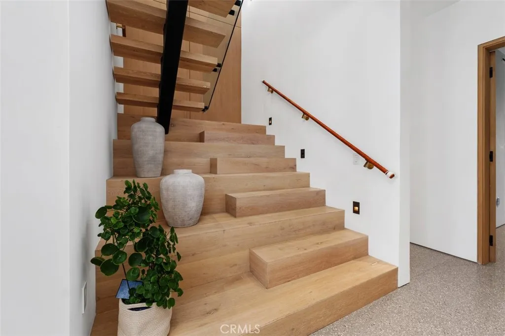 Beautiful Oak staircase and hand wrapped leather hand rails leads to second level