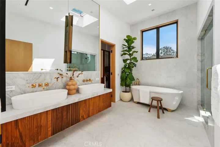 En-suite with Italian marble, skylight, soaking tub, shower and brass fixtures