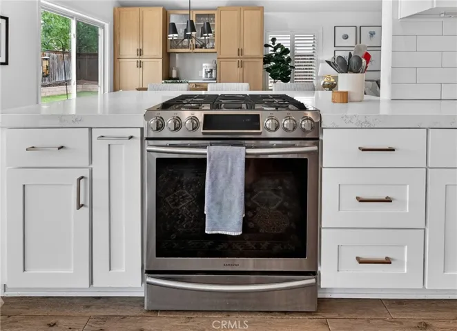 Stainless steel Samsung range with hood above
