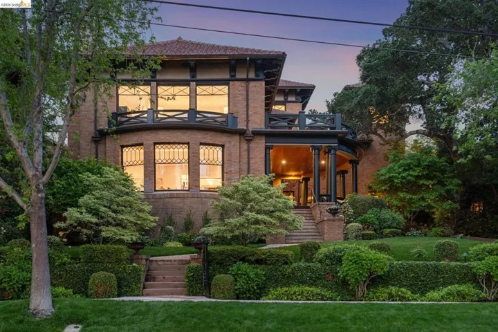 View of front facade with brick siding, a balcony, and a front lawn