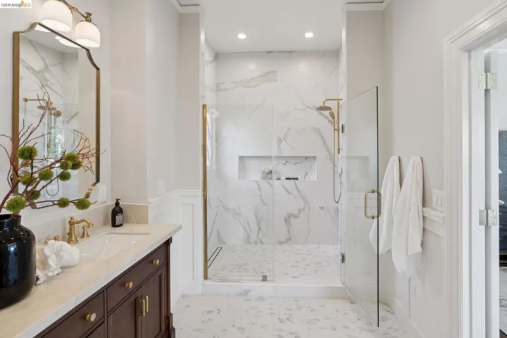 Bathroom with vanity, a marble finish shower, recessed lighting, and a wainscoted wall