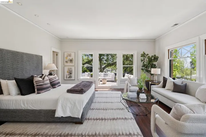 Bedroom with ornamental molding, multiple windows, and wood finished floors