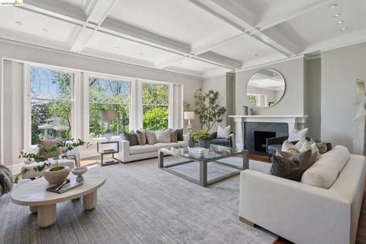 Living room with coffered ceiling, a premium fireplace, recessed lighting, and crown molding