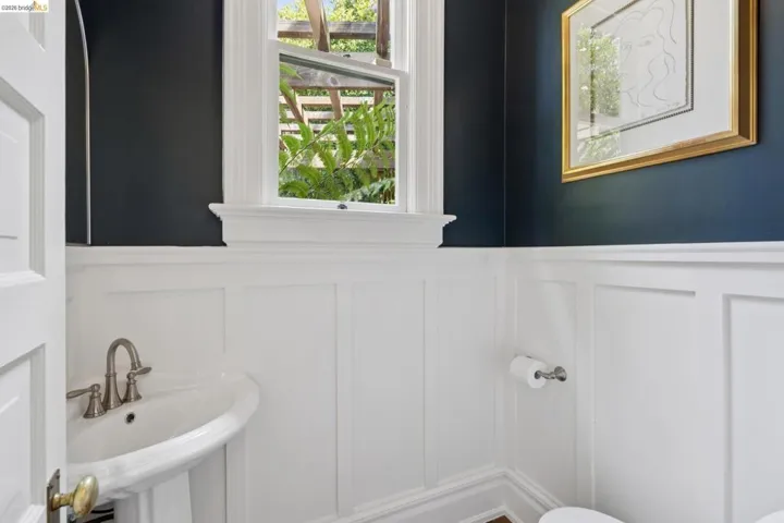 Half bathroom featuring a decorative wall and a wainscoted wall