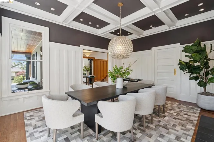 Dining space with a decorative wall, light wood-type flooring, coffered ceiling, and recessed lighting