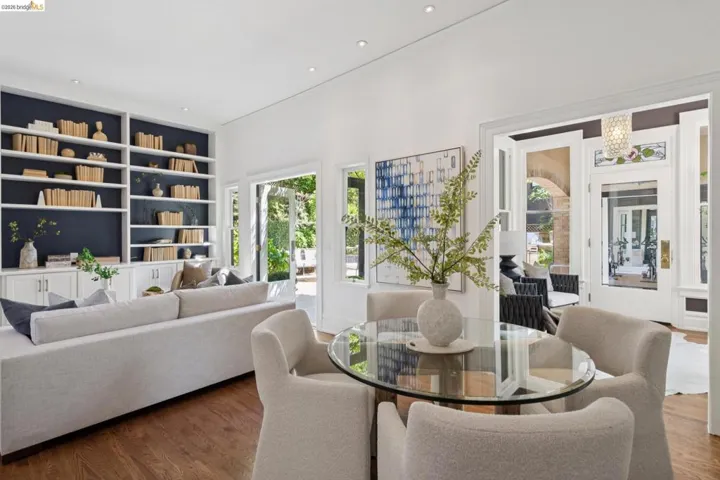 Dining room with built in shelves, hanging lights, and wood finished floors