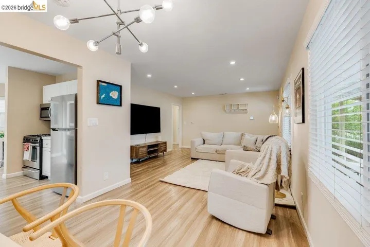 Living area featuring light wood-type flooring and hanging lights