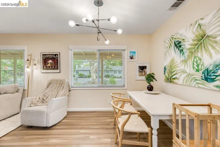 Dining space featuring light wood finished floors, suspended lighting, and healthy amount of natural light