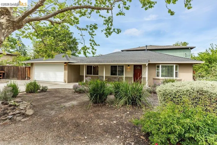 Ranch-style house featuring an attached garage, concrete driveway, stucco siding, and a shingled roof