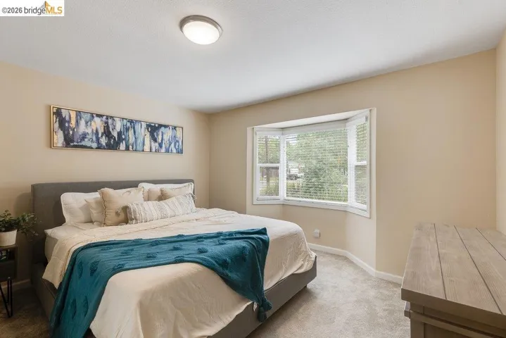 Bedroom with light colored carpet and baseboards