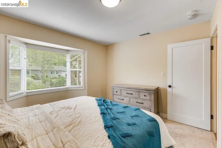 Bedroom featuring light carpet and baseboards