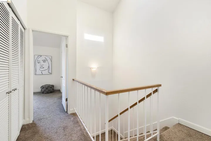Hall featuring carpet and an upstairs landing