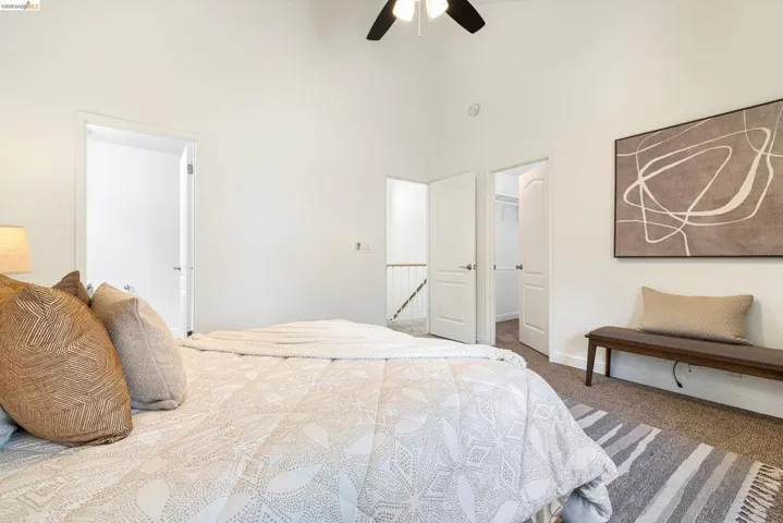 Bedroom with carpet floors, a high ceiling, ceiling fan, and a walk in closet