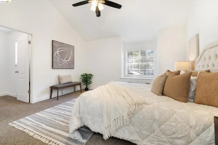 Bedroom featuring carpet, lofted ceiling, and ceiling fan