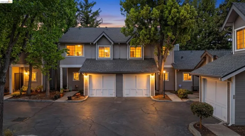 Traditional home featuring driveway, a shingled roof, and an attached garage