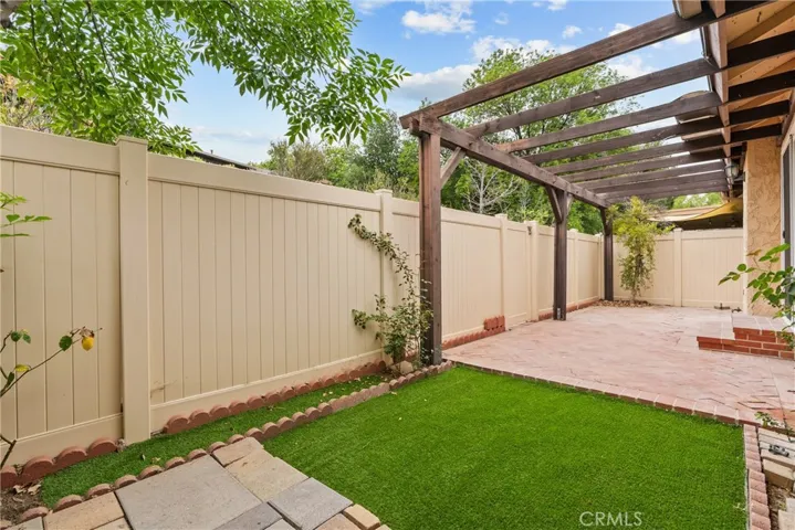 Backyard patio with turf and door to exterior.
