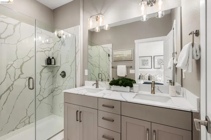 Full bathroom with ensuite bath, a marble finish shower, and double vanity