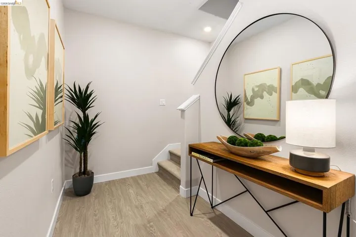 Hall featuring light wood finished floors, stairway, and recessed lighting