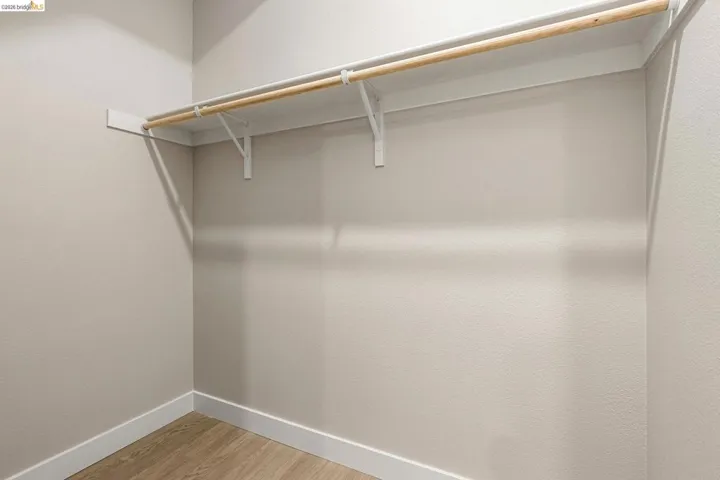 Walk in closet with light wood-style floors