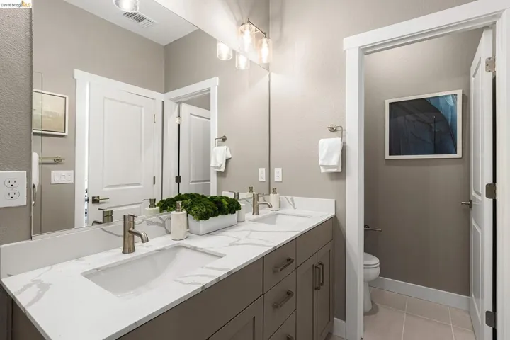 Bathroom with double vanity and tile patterned flooring