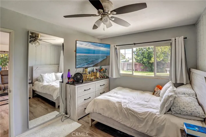 Secondary bedroom with large window and ceiling fan.